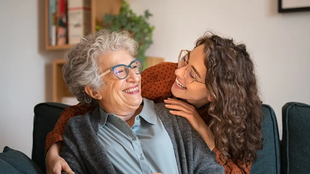 A younger person embracing an older person